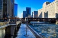 Footprints on riverwalk alongside a frozen Chicago River with ice chunks. Royalty Free Stock Photo