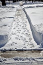 Footprints on the snow. Sidewalk cleared from heavy snow. Royalty Free Stock Photo