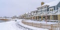 Footprints on snowy path along lakefront homes