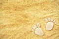 Footprints of stones on yellow sand on the beach in summer