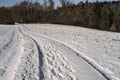 Footprints and tyre tracks in a snowy country lane Royalty Free Stock Photo