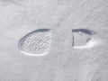 Footprints of a woman`s boot in the snow. A clear imprint of the pattern of the sole of the boots on a snowy field