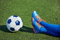 Foots boy soccer in football boots with ball on grass