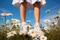 Foots of girl in shoes on white daisies field. Royalty Free Stock Photo