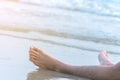 Foots of man relaxing on beach