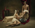 Modern remake of classical artwork with coronavirus theme - young medieval couple on dark background