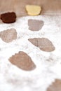 Footsteps on icing sugar, dark and white foot shaped cookies in the background