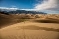 Footsteps Lead To Hiker Crossing The Sand Dunes