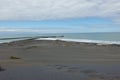 Footsteps leading down black sand-dunes to waters edge Royalty Free Stock Photo