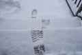 Footsteps in snow on staircase close-up top view. Winter season. natural background Royalty Free Stock Photo