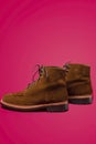 Footwear Concepts. Tan Brown Suede Split Toe High Boots Closeup With Visible Leather Texture Placed Over Pink Red Background Royalty Free Stock Photo