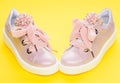 Footwear for girls or women decorated with pearl beads. Glamorous footwear concept. Pair of pale pink female sneakers Royalty Free Stock Photo