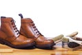 Footwear Ideas and Concepts. Closeup of Tanned Mens Derby Boots With Cleaning Brushes and Wax