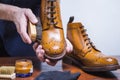 Footwear Ideas. Hands of Professional male Shoes Cleaner with Brush