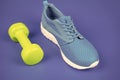 footwear for training with dumbbell on blue background, sport accessory