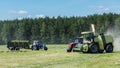 Forage harvester cutting grass silage crop in field and filling tractor trailer Royalty Free Stock Photo
