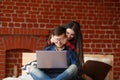 Forbidden content concept. Happy couple with laptop spending time together at home, smiling and having fun. Royalty Free Stock Photo