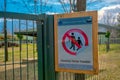 Forbidden sign hanging on zoo park and it says no entrance. Sing board hangin on green fences made of metal.