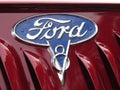 Ford company logo with V8 insignia on the hood of a classic car at an auto show