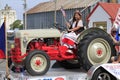 A Ford tractor in a parade with a Czech girl sitting in the tractor seat Royalty Free Stock Photo