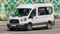 Ford Transit Fourth generation in the city street. Front side view of white light commercial vehicle Royalty Free Stock Photo