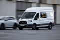 Ford Transit Fourth generation in the city street. Front side view of white light commercial vehicle Royalty Free Stock Photo