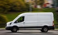 Ford Transit Fourth generation in the city street. Side view of white light commercial vehicle Royalty Free Stock Photo