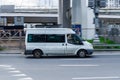 Ford Transit Third generation in the city street. Side view of white urban public transit minibus