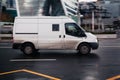 Ford Transit Third generation van in the city street. Side view of white panel van, light commercial vehicle speeding on wet, Royalty Free Stock Photo