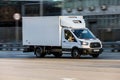 Ford Transit truck fourth generation in the city street. Front side view of white light commercial vehicle