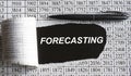 FORECASTING is the word behind torn office paper with numbers and a black pen Royalty Free Stock Photo