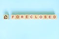 Foreclosed property concept in real estate. Wooden blocks typography