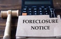 FORECLOSURE NOTICE - words on light brown paper against the background of a calculator and a judge\'s gavel Royalty Free Stock Photo