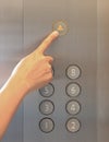 Forefinger pressing the alarm bell button in the elevator Royalty Free Stock Photo