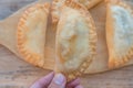 A foreground of Argentinean empanadas a background of rustic wood