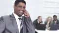 Foreground of a businessman talking on a mobile phone in the of