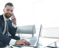 Foreground businessman talking on a smartphone