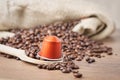 In the forground Wooden spoon and coffee capsule Royalty Free Stock Photo