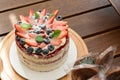 In the foreground defocused chocolate lollipops. Red velvet cake with strawberries and blueberries and basil leaves to decorate. Royalty Free Stock Photo