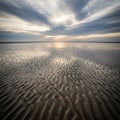 Foreground features intricate ripple patterns in the sand created by Royalty Free Stock Photo