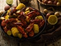 In the foreground of the photo, we see boiled corn and crayfish. On the right is half a lemon. In the background are different Royalty Free Stock Photo