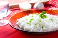 White rice and rice with bowl with cold water and garlic and onion in the background