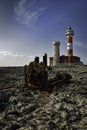 Toston lighthouse Faro de Toston in Fuerteventura with rusty ship wreck in foreground on rocks