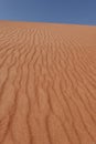 In the foreground vertical wavy streaks of the Rub al Khali desert sand. Oman Royalty Free Stock Photo