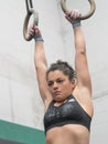 Woman athlete hung of the rings in the gym