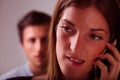 Foreground woman on call, jealous man blurred Royalty Free Stock Photo