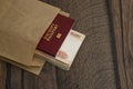 Foreign passport and bundle of cash money peep out of opaque envelope