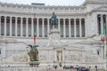 Foreign tourists strolling on the tour and take pictures near the Vittoriano monument on Piazza Venezia in Rome on slopes of Capit