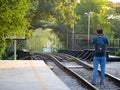 Foreign tourists taking pictures of train tracks tree tunnel backdrop Royalty Free Stock Photo