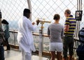 Foreign tourists with telescope on Eiffel tower